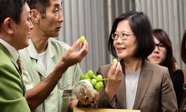 圖為蔡英文8日參觀大田批發市場並試吃「翡翠綠葡萄」。(取自蔡英文臉書)
